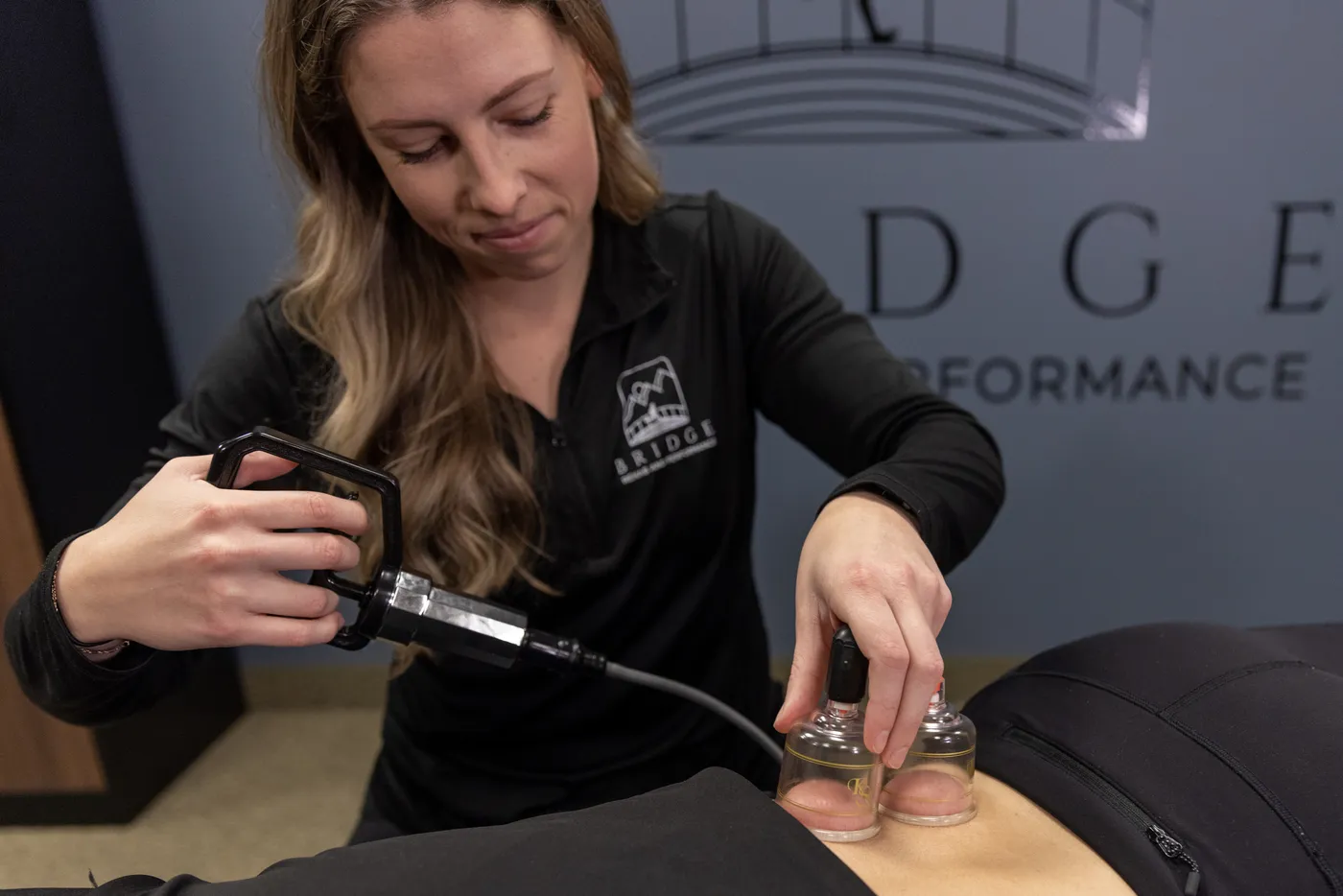 A Bridge physical therapist performing cupping therapy on a patient